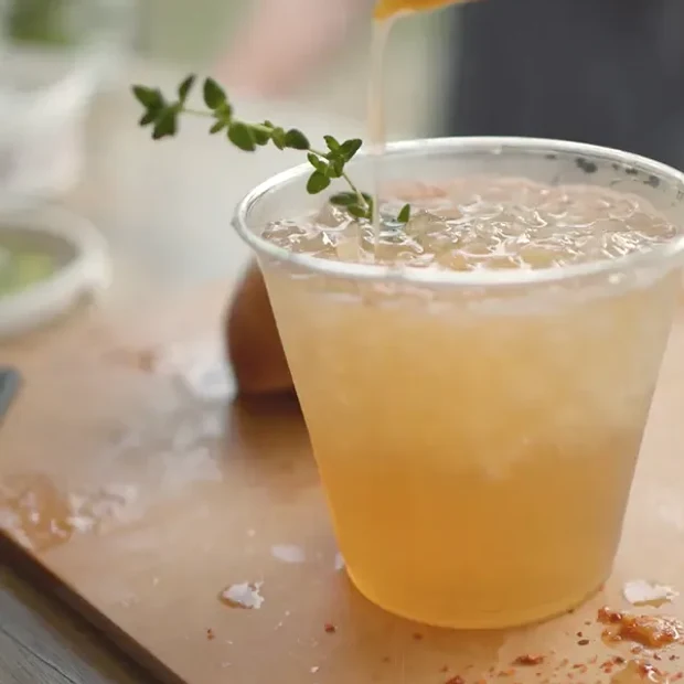 A craft cocktail garnished with fresh herbs