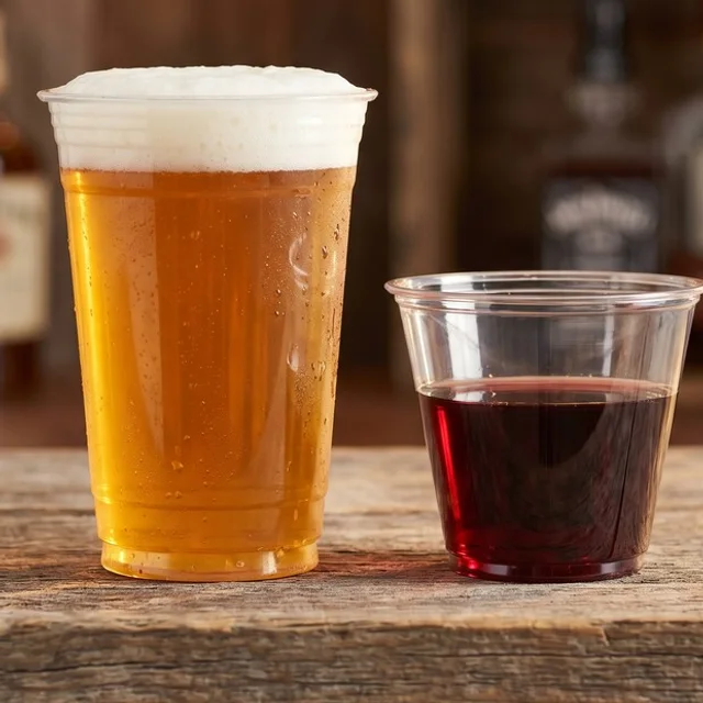 A plastic cup of beer and a plastic cup of red wine on a Steel Pony bar