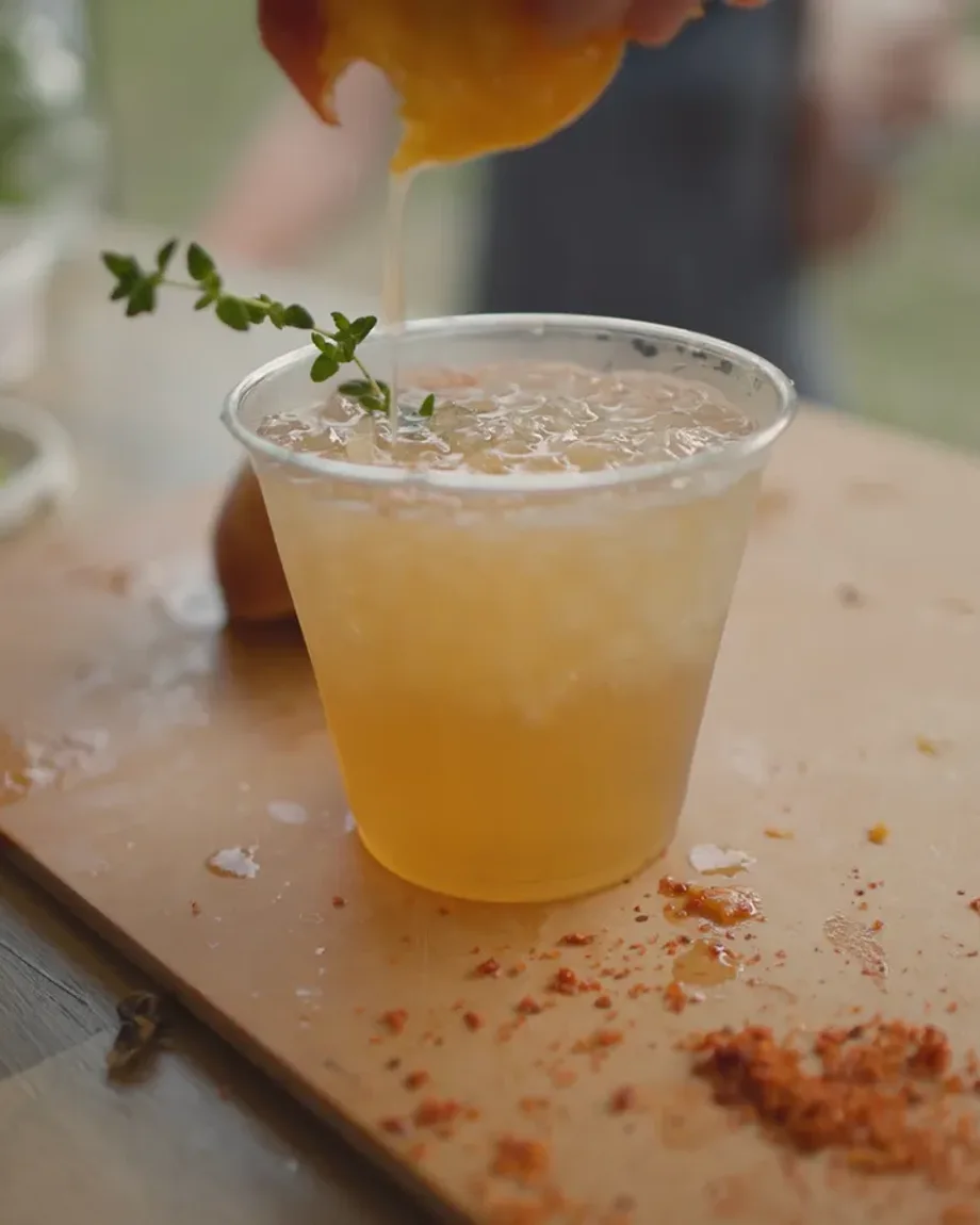 A craft cocktail poured over crushed ice with fresh thyme at a Steel Pony event bar