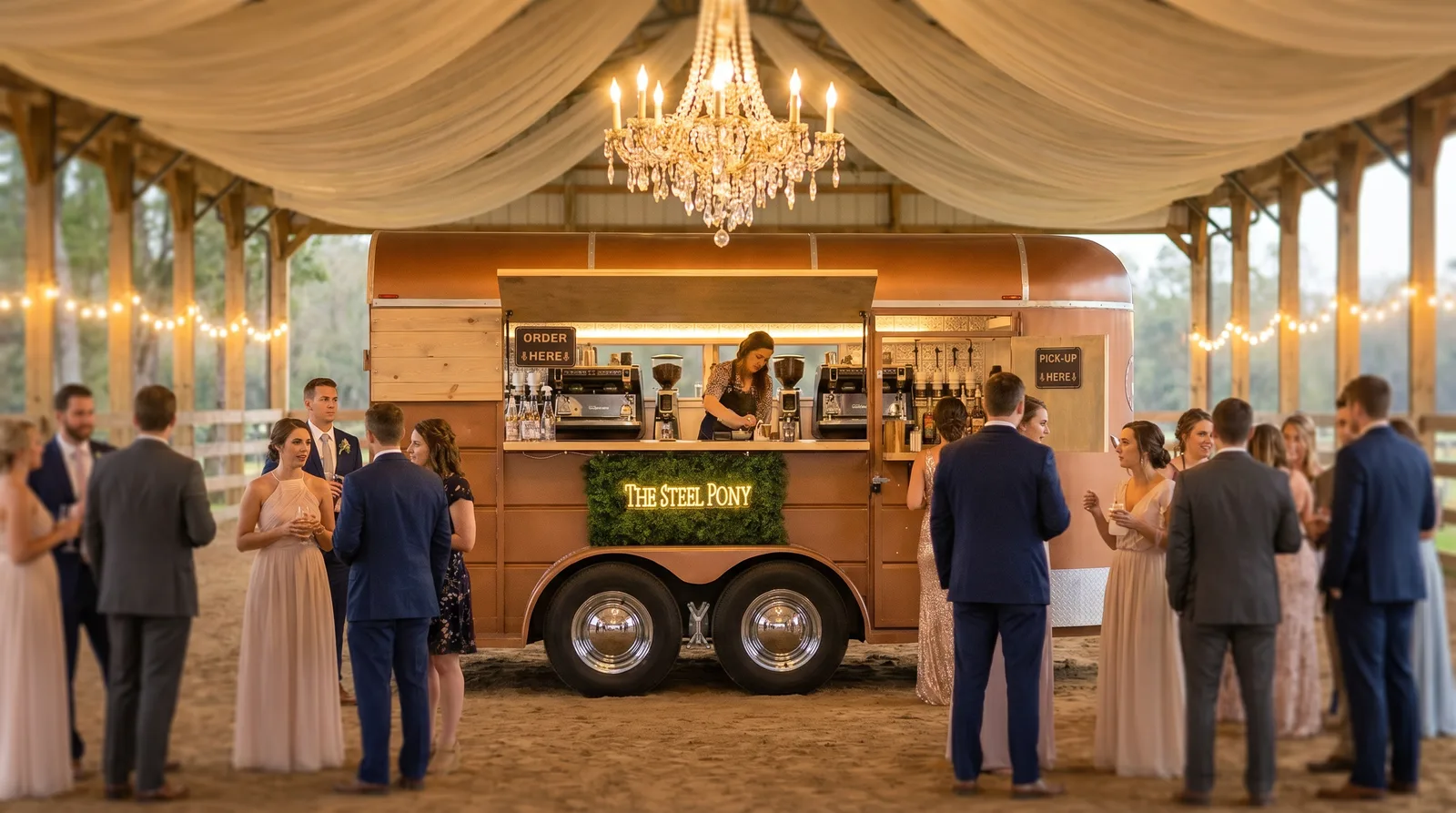 The horse-trailer bar inside a draped barn reception under a chandelier